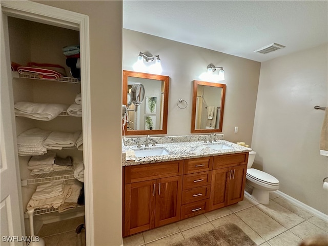 bathroom with tile patterned floors, vanity, and toilet