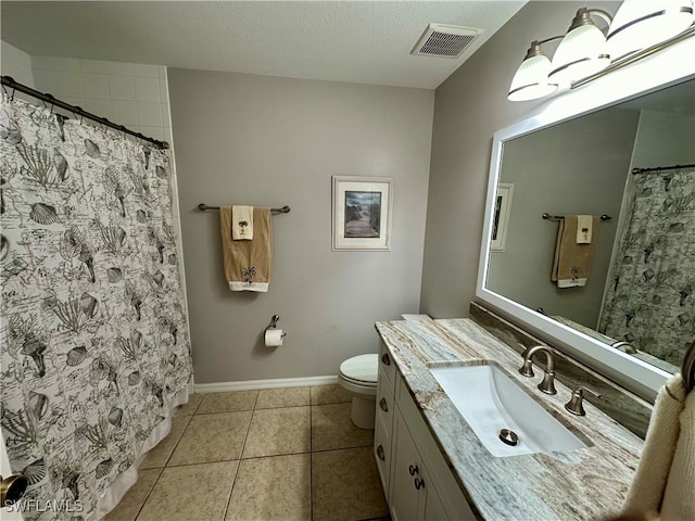 bathroom with tile patterned flooring, vanity, a textured ceiling, and toilet