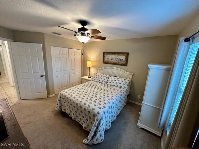 carpeted bedroom featuring a textured ceiling, a closet, and ceiling fan