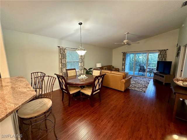 dining room with ceiling fan, dark wood-type flooring, and vaulted ceiling