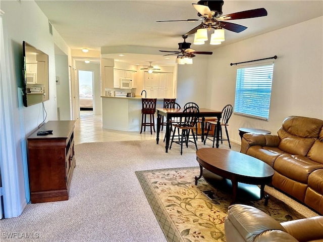 living area featuring light tile patterned floors, baseboards, and light colored carpet