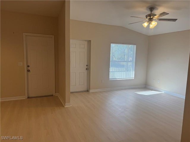 spare room featuring ceiling fan, lofted ceiling, and light wood-type flooring