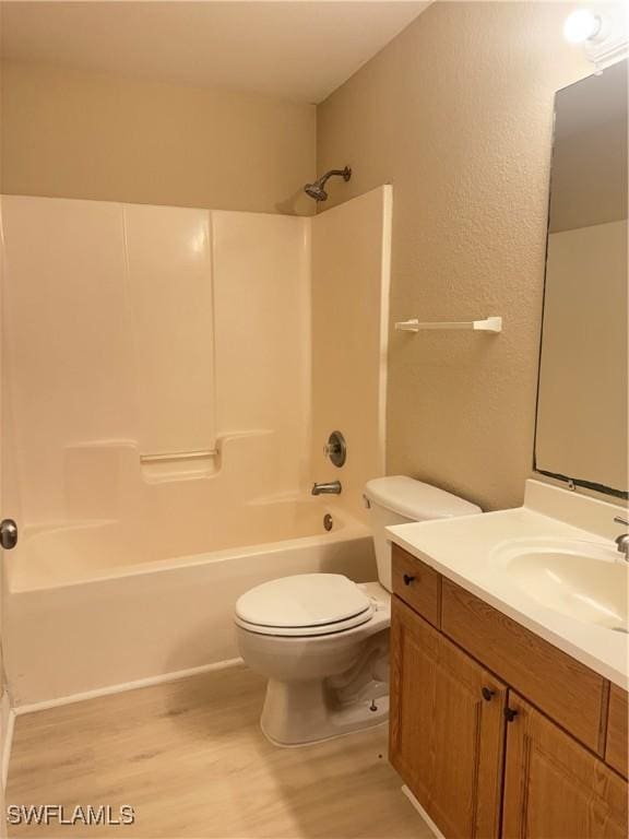 full bathroom featuring shower / bathing tub combination, hardwood / wood-style floors, vanity, and toilet