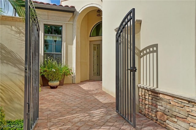 doorway to property with a gate and stucco siding