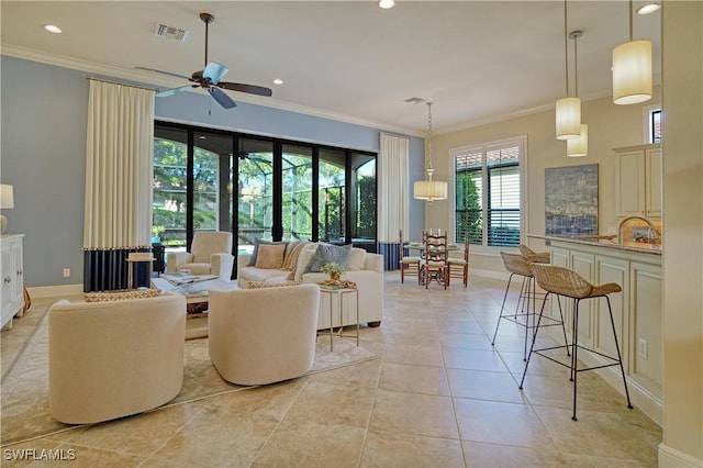 living area featuring crown molding, light tile patterned floors, recessed lighting, visible vents, and baseboards