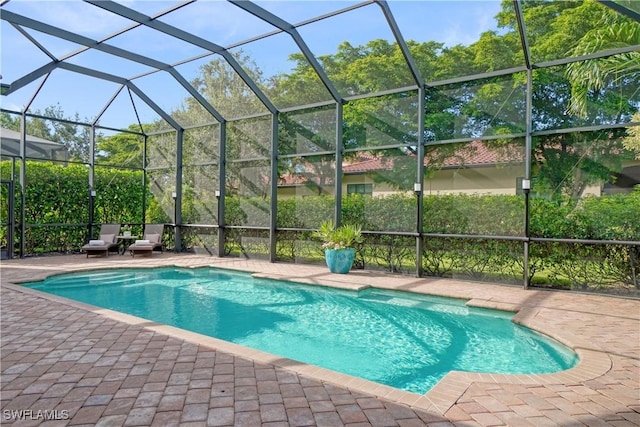 pool with glass enclosure and a patio