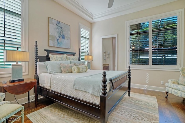 bedroom featuring ornamental molding, dark wood-style flooring, baseboards, and a ceiling fan