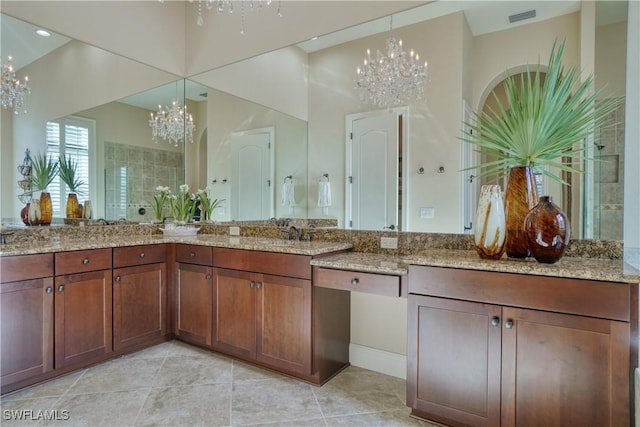 bathroom featuring a chandelier, a tile shower, vanity, and tile patterned floors