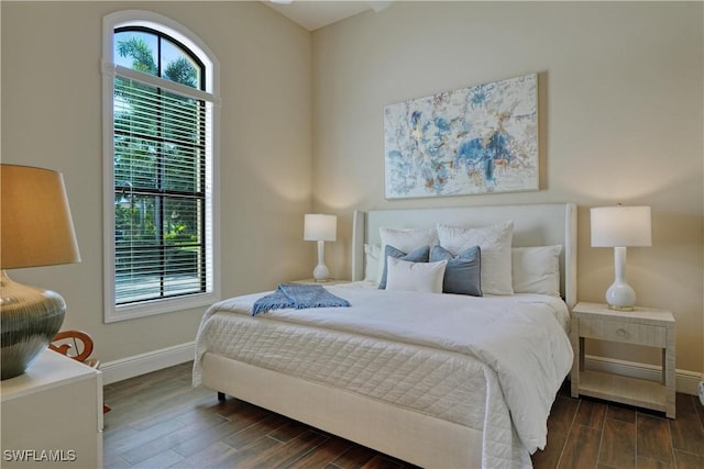 bedroom featuring dark wood-style floors and baseboards