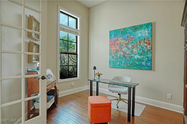 office with french doors, wood finished floors, and baseboards