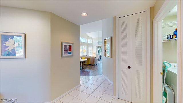 hallway with recessed lighting, independent washer and dryer, baseboards, and light tile patterned floors