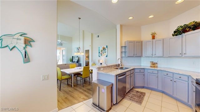 kitchen with a peninsula, a sink, hanging light fixtures, backsplash, and dishwasher