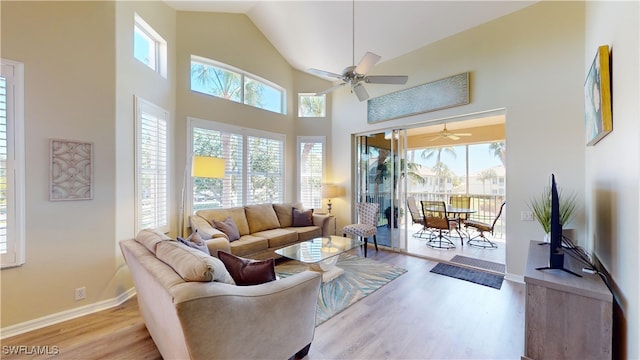 living room featuring ceiling fan, high vaulted ceiling, and light hardwood / wood-style floors