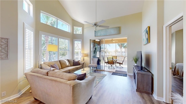 living room with ceiling fan, a healthy amount of sunlight, and light wood-type flooring