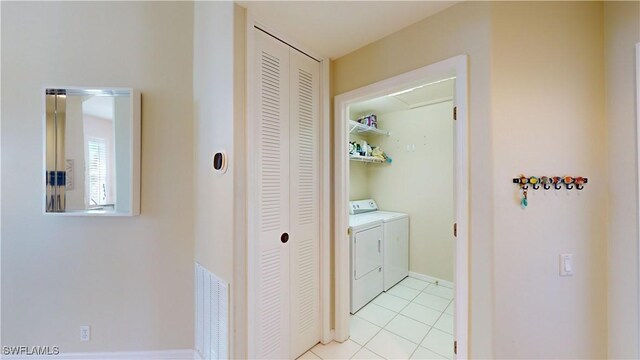 corridor featuring light tile patterned flooring and washer and dryer