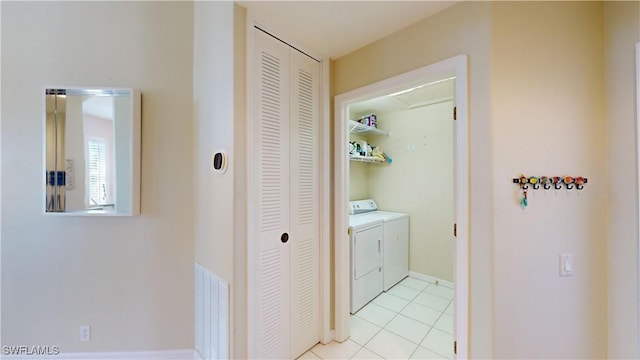 laundry area featuring laundry area, visible vents, washer and clothes dryer, and light tile patterned flooring