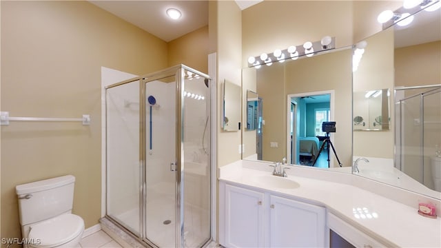 bathroom featuring a shower with shower door, toilet, vanity, and tile patterned floors