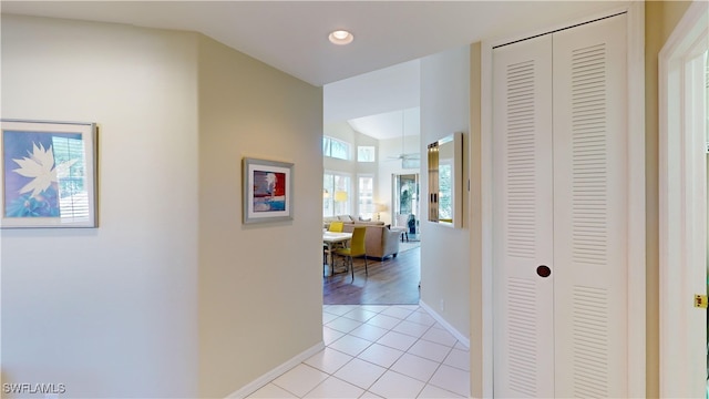 corridor with recessed lighting, baseboards, and light tile patterned floors