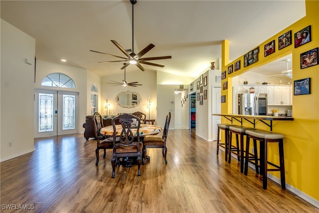 dining space featuring hardwood / wood-style floors, high vaulted ceiling, french doors, and ceiling fan