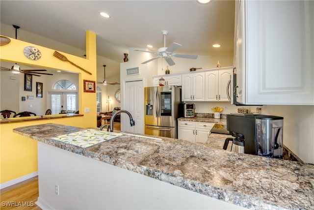 kitchen featuring stainless steel fridge with ice dispenser, kitchen peninsula, ceiling fan, and white cabinetry