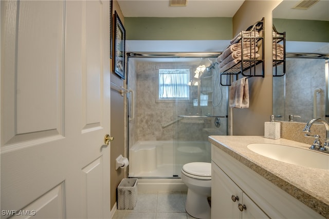 bathroom with tile patterned floors, vanity, walk in shower, and toilet