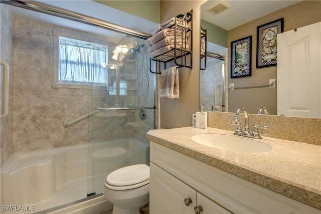 bathroom featuring toilet, walk in shower, and vanity