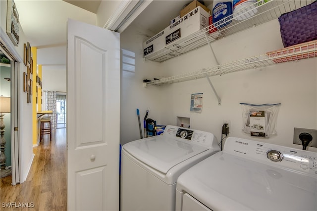 washroom with light hardwood / wood-style flooring and washer and clothes dryer