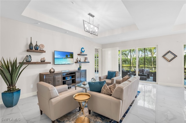 tiled living room featuring an inviting chandelier and a tray ceiling