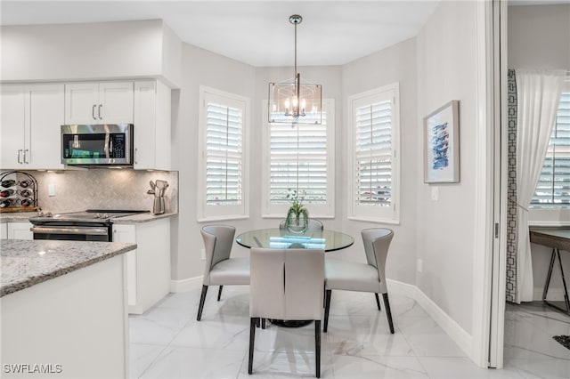 dining area with light tile patterned flooring, a wealth of natural light, and a chandelier