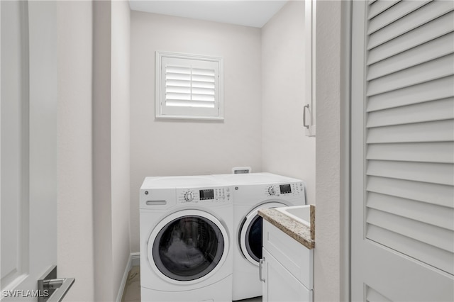 laundry room with independent washer and dryer and cabinets