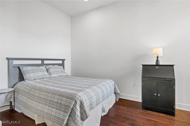 bedroom with dark hardwood / wood-style flooring