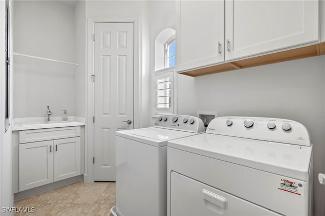 clothes washing area with washer and dryer, cabinets, light tile patterned floors, and sink