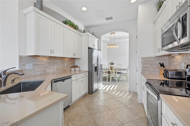 kitchen with sink, light tile patterned floors, decorative backsplash, white cabinets, and appliances with stainless steel finishes