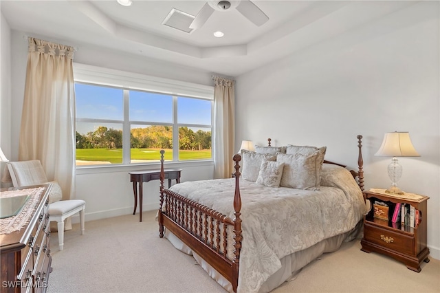 bedroom with a tray ceiling, ceiling fan, and light carpet