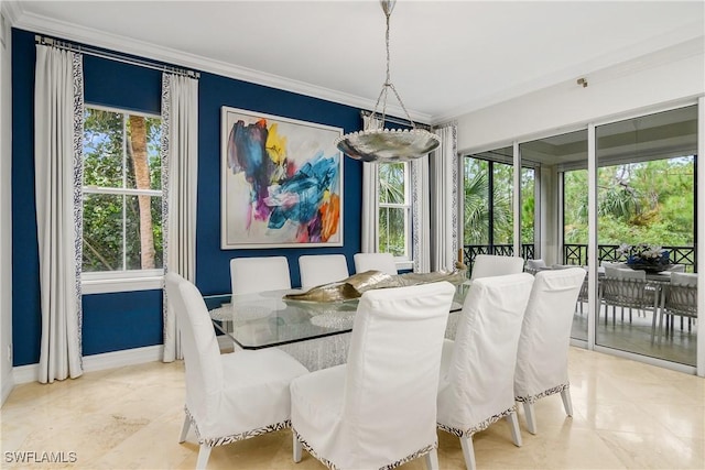 dining room with a wealth of natural light, crown molding, and baseboards