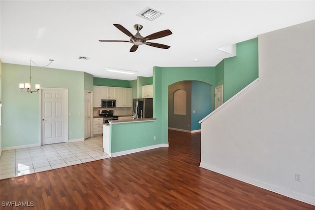 unfurnished living room with light hardwood / wood-style floors and ceiling fan with notable chandelier