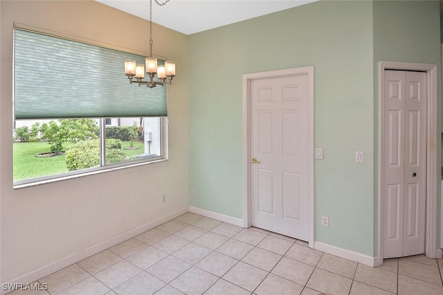 empty room featuring light tile patterned floors and a notable chandelier