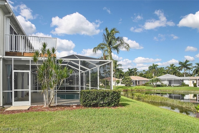 view of yard with glass enclosure and a water view