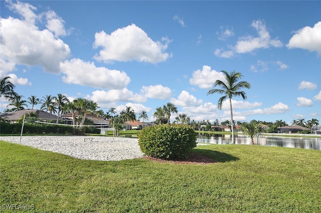 view of home's community featuring volleyball court, a lawn, and a water view