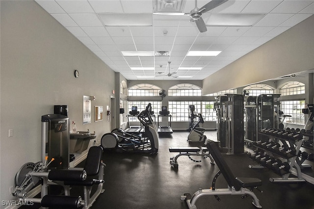 exercise room with ceiling fan and a paneled ceiling