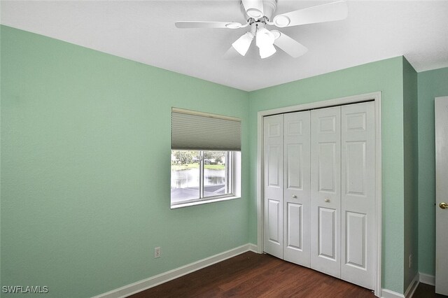 unfurnished bedroom featuring dark hardwood / wood-style flooring, a closet, and ceiling fan