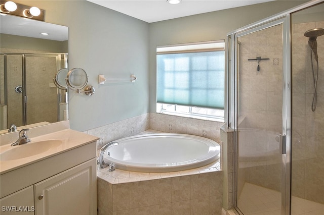 bathroom with shower with separate bathtub and vanity