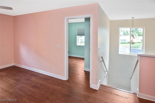 unfurnished room with dark hardwood / wood-style floors and a chandelier