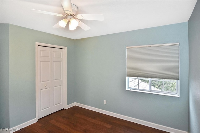 unfurnished room with ceiling fan and dark wood-type flooring