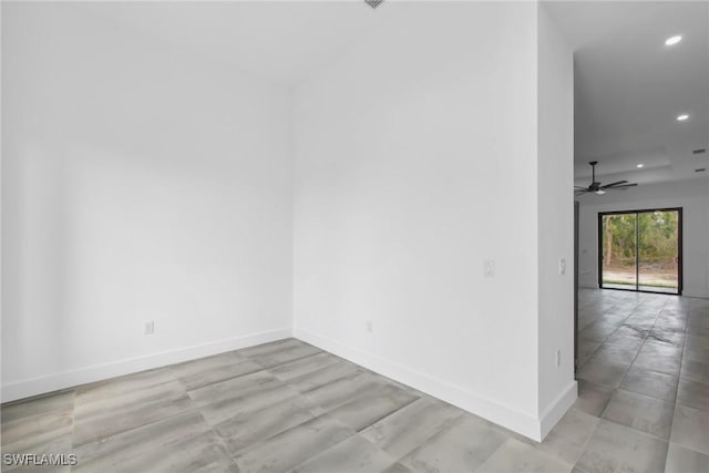 spare room with recessed lighting and baseboards