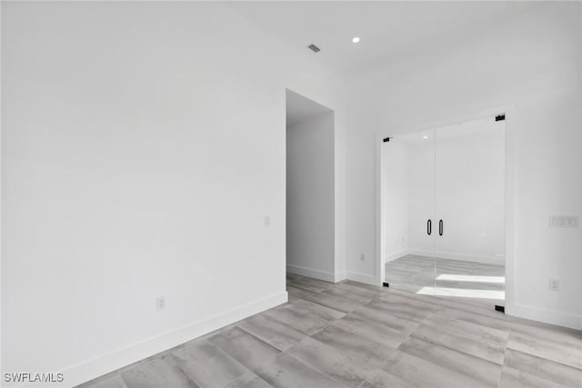 unfurnished room with recessed lighting, visible vents, and baseboards