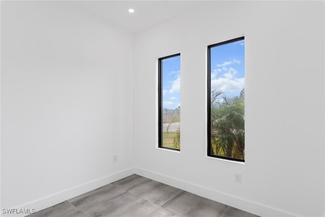 unfurnished room with recessed lighting and baseboards