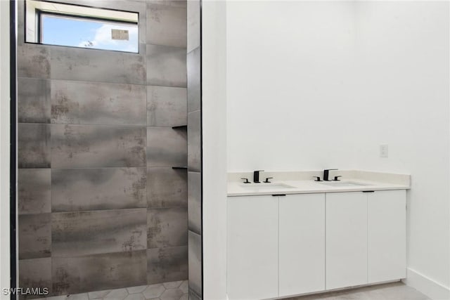 full bathroom with double vanity, baseboards, and a sink