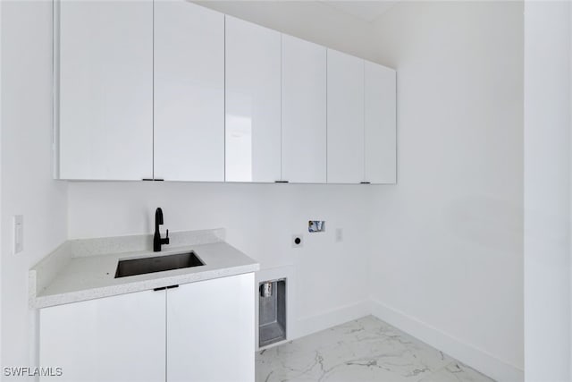 laundry area featuring hookup for an electric dryer, a sink, baseboards, marble finish floor, and cabinet space