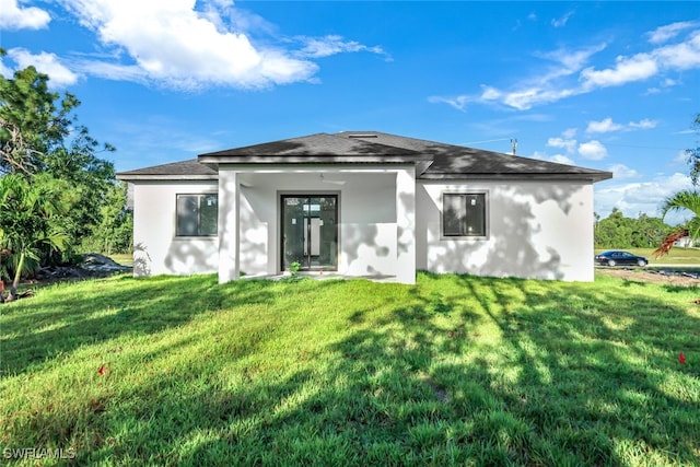 prairie-style home with an attached garage, roof with shingles, decorative driveway, stucco siding, and a front yard